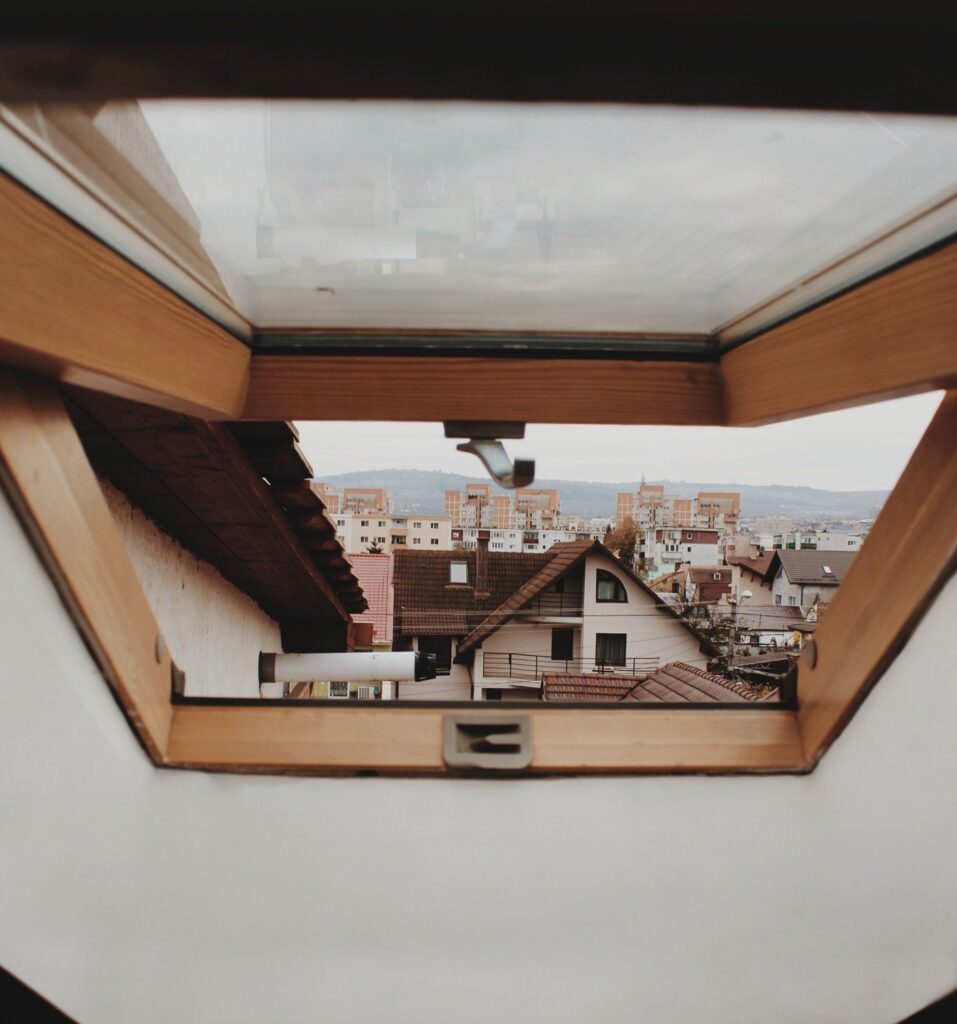 Charming architectural view of Cluj-Napoca through a skylight, showcasing urban rooftops and cityscape.